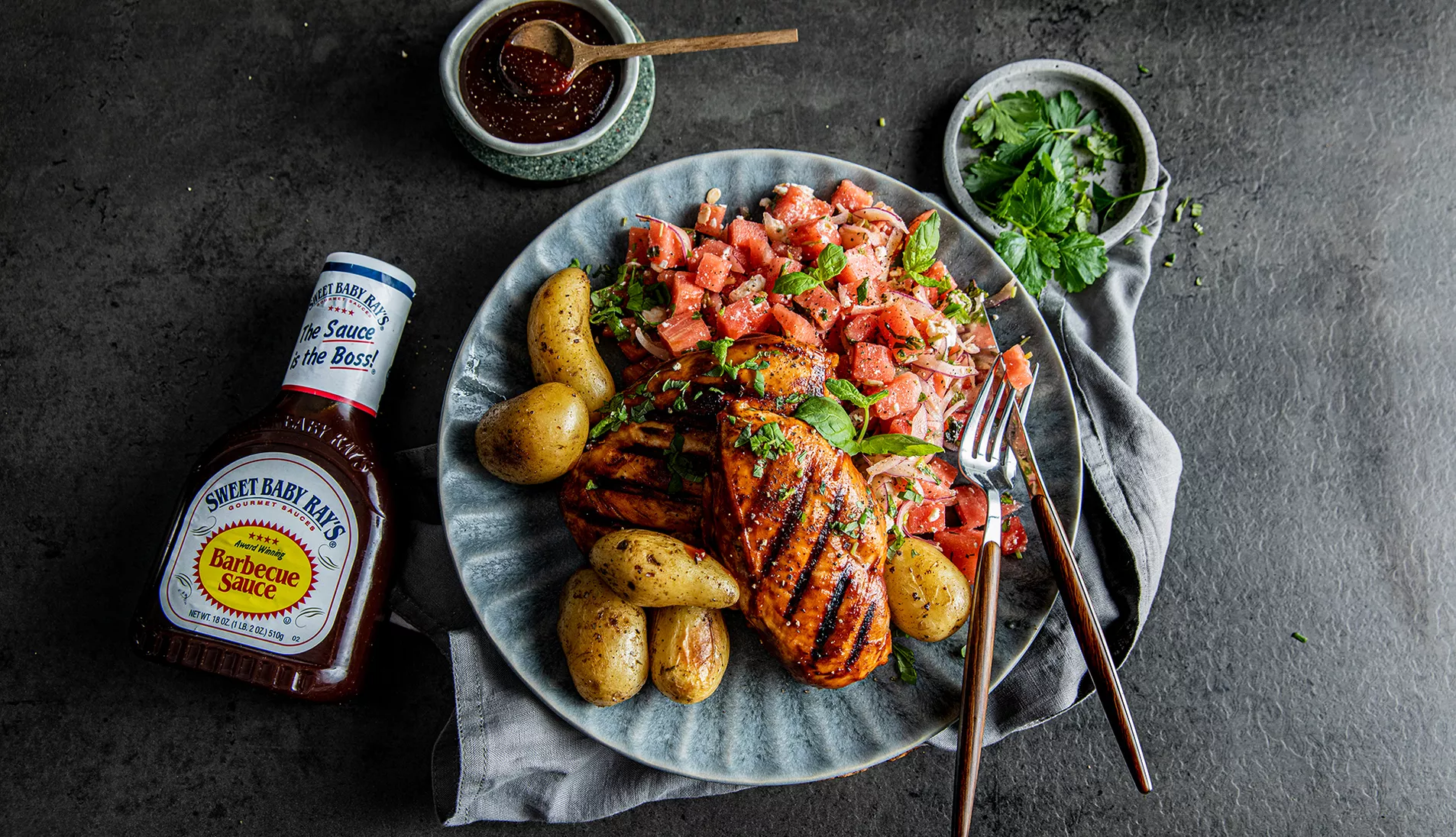 Grillet kyllingbryst med vannmelonsalat. En flaske Sweet Baby Ray's BBQ-saus ligger ved siden av