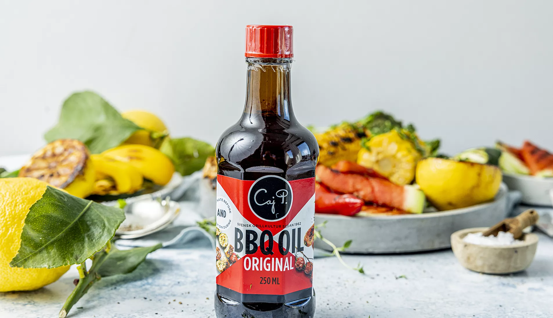 grillede grønnsaker med en flaske Caj P grillolje stående foran