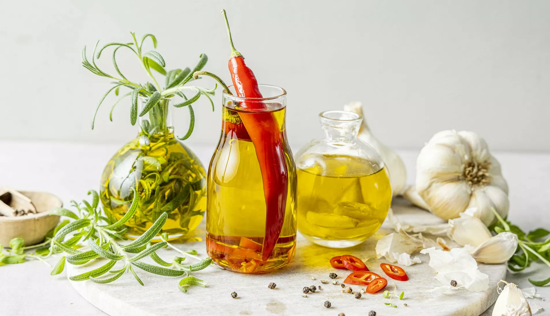 Liten glassflaske med olivenolje og en hel, rød chili